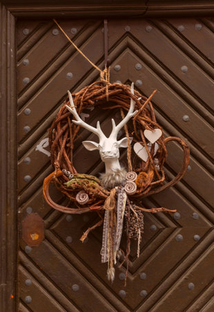Wreath with deer head and natural ornaments on wooden door in Rothenburg ob der Tauber Germanyの写真素材