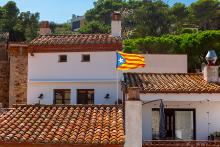 Flag flying over traditional house in Tossa de Mar Spainの写真素材