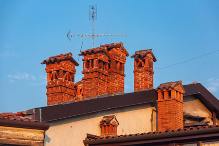 Close-up of traditional brick chimneys with roof tiles in Bergamo, Lombardy, Italyの写真素材