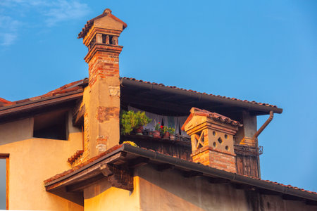 Close-up of traditional brick chimneys with roof tiles in Bergamo, Lombardy, Italyの写真素材