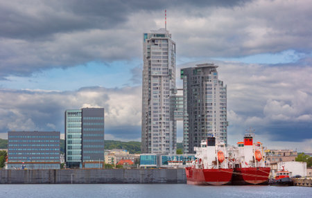 Two red cargo ships and Sea Towers skyscraper at the harbor in Gdynia, Polandの写真素材