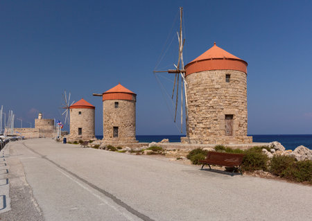 Stone windmills along Mandraki harbor promenade in Rhodes, Greeceの写真素材