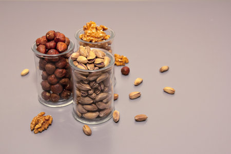 hazelnut, walnut and pistachio nut. mixed assorted nuts in glass box on light background