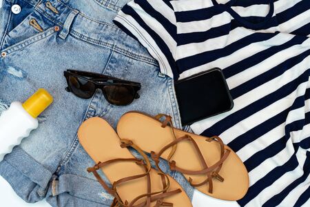 Flat lay summer traveler beach accessories. Top view travel or vacation concept. Jean and beach sandals and sun glasses layoutの写真素材