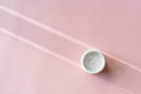Cosmetic skin face care cream moisturize on pink background. Cosmetology body care lotionの写真素材