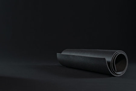 yoga mat for practicing yoga positions, sport workout fitness exercise. dark background. copy space