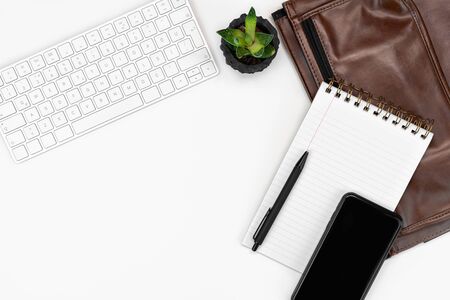 flatlay of White office desk table layout. computer keyboard, glasses, smartphone, notebook and laptop case. copy space layoutの写真素材