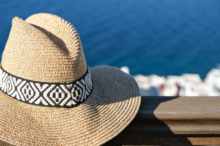 straw hat with on wooden terrace of holiday villa or hotel with sea view