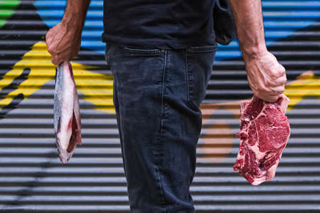 man holding Raw beef steak and and fresh fish protein foodの写真素材