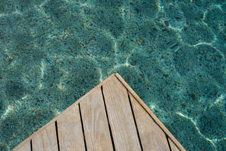 Top view of wood platform or terrace jetty beside the blue crystal clear water background.
