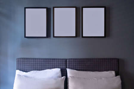 Modern bedroom in luxury apartment in dark blue colors with picture foto frames.の写真素材
