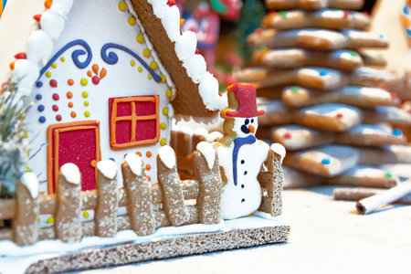 gingerbread house and gingerbread christmas decoration in the snow