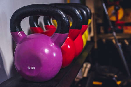 different color iron kettlebells in gym workoutの写真素材