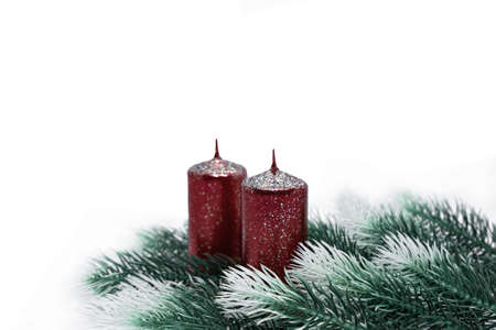 Christmas tree branches with snow effect red candles on white background, New yearの写真素材