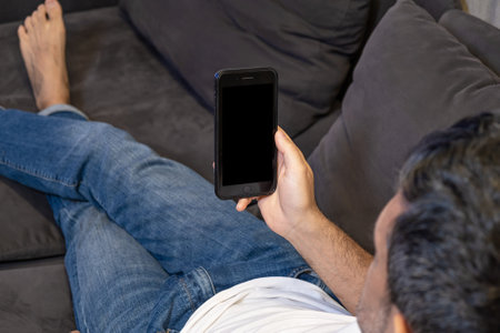 man holding using smart phone at home. Online education, working, shoppingの写真素材