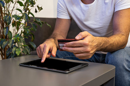 online shopping man paying order online with tablet and credit card from home