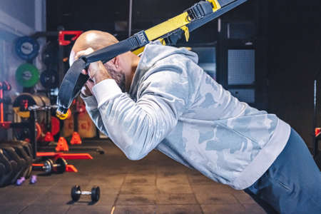 Man Does Crossfit exercise With Trx Fitness Straps In Gymのeditorial素材