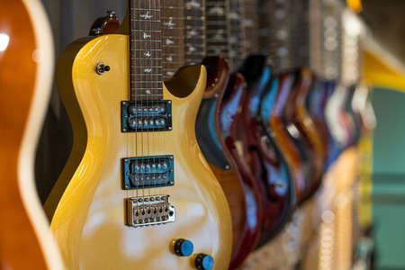 Row of electric guitars different color in a music instruments shopの写真素材