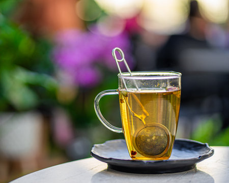 cup of fresh aromatic tea on table with nature flowers backgroundの写真素材