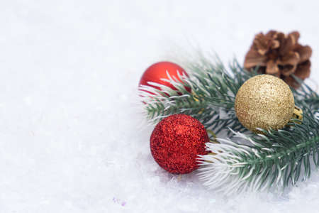 Christmas composition of Christmas tree toy red and gold ball snow background tree branch coneの写真素材