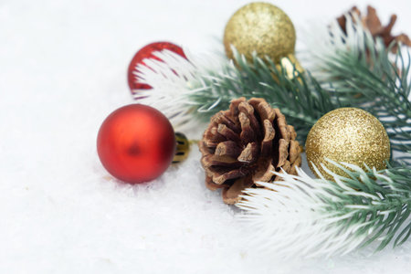 Christmas composition of Christmas tree toy red and gold ball snow background tree branch coneの写真素材