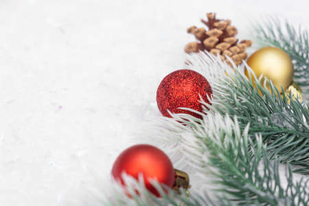 Christmas composition of Christmas tree toy red and gold ball snow background tree branch coneの写真素材