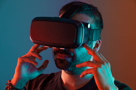 Young man in VR glasses close up portrait virtual reality in color neon light, future technology,...