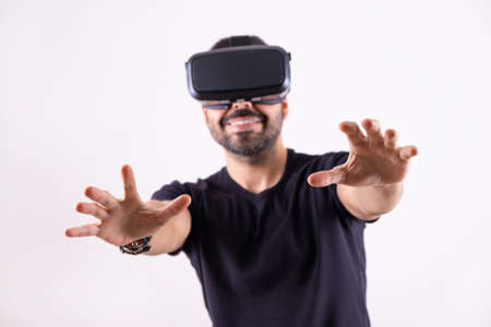 Young man in VR glasses headset gesturing portrait. Virtual reality, future technology, education video gamingの写真素材