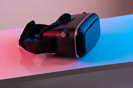 Black VR glasses mask on neon color background. Virtual reality headsetの写真素材
