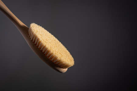 wooden brush for body dry massage anti cellulite peeling body care. on dark background Close-upの写真素材