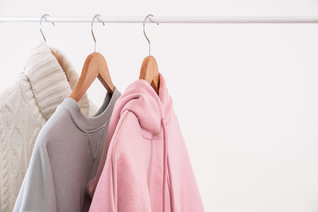 Pastel colors casual female clothes on wooden hangers on open rail copy space close upの写真素材
