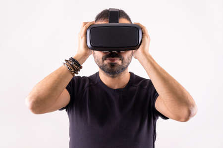 Young man using VR glasses headset holding with hands, portrait. Virtual reality, future technology, education video gamingの写真素材
