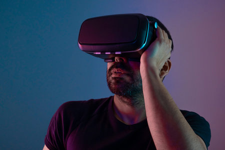 Young man in VR glasses close up portrait virtual reality in color neon light, future technology,...
