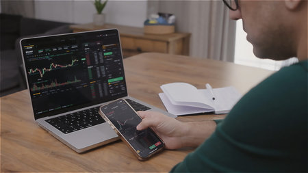 Young financial analyst professional buy and sell crypto on stock market using laptop and...