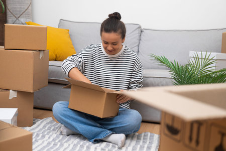 New Beginnings: A woman in her recently acquired home, amidst carton boxes, reveals her lifes...