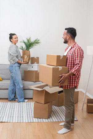 Happy man and woman collect things in cardboard boxes to sent to another address for new apartment...