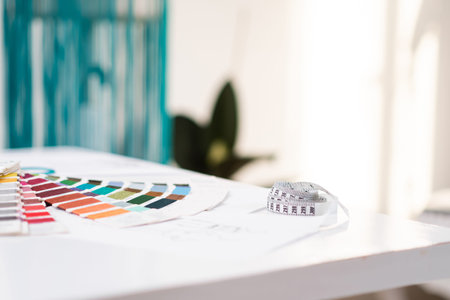 Color swatch palette and measuring tape on table in fashion shop sewing tools and supplies on...