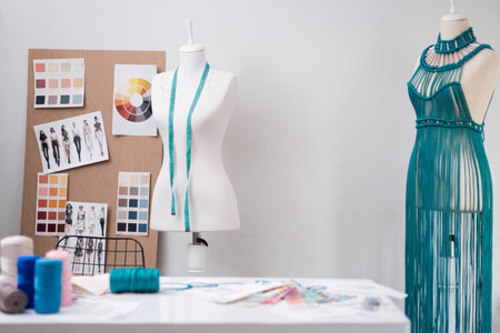 Trendy macrame dress of green threads in dummy in dressmaking shop sewing fashionable women clothes...
