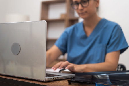 Digital Medical Consult: Engaged in online healthcare, a female doctor on her laptop showcases...