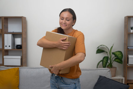 smiling customer cradles her parcel, embodying satisfaction and the convenience of home delivery...