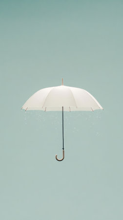 Minimalist image of a white umbrella levitating in a light green sky with rain drops falling from its edges, conveying a sense of surrealism and tranquilityの素材