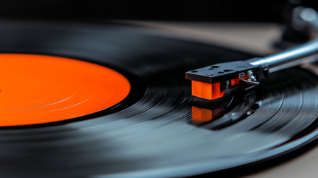 Close up of a record players needle playing a spinning vinyl record with an orange label, capturing the essence of analog music and sound reproductionの素材