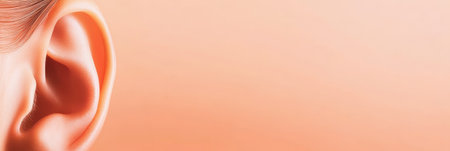 Highlighting a clean, healthy ear against a soft peach background, creating a visually appealing image for healthcare, audiology, and wellness campaigns promoting auditory healthの素材
