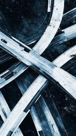Complex network of overpasses and ramps creating an intricate pattern of transportation infrastructure against a dark, textured backdrop, symbolizing urban connectivity and mobilityの素材