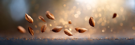 Dry autumn leaves gently falling onto a dark surface, illuminated by a warm, golden light, creating a magical and enchanting autumnal sceneの素材