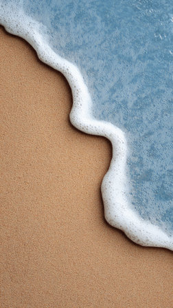 Crystal clear turquoise water forms a delicate white foam as it washes over the smooth, golden sand of a pristine tropical beach, creating a serene and idyllic scene of coastal tranquilityの素材