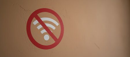 No wifi symbol on a textured wall warning about a lack of wireless internet connection, representing technical issues and offline status in data communicationの素材