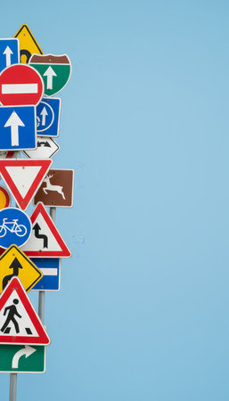 Cluster of traffic signs on a pale blue background symbolizing the many rules, directions and decisions involved in learning to drive, navigation, and road safety awarenessの素材