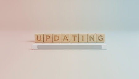Wooden blocks spelling updating symbolize the process of software or system enhancement, featuring a loading bar illustrating data transfer and technological advancement in a digital environmentの素材