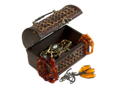 wooden casket and jewellery from amber isolated on white
